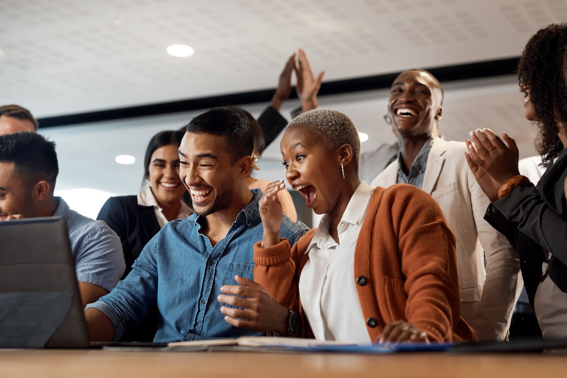 Shot of a group of young businesspeople using a laptop and looking shocked in a modern office